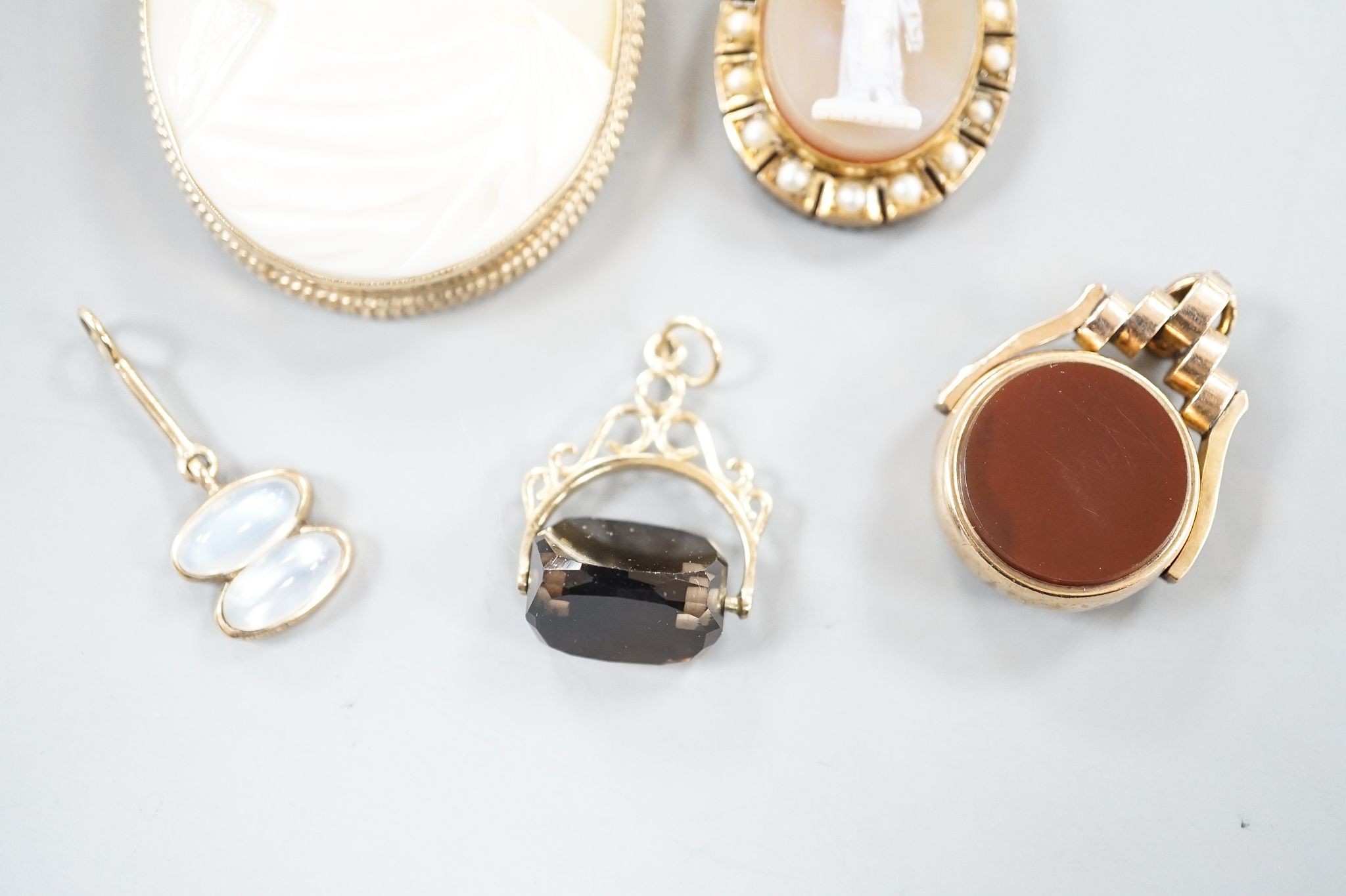 A modern 9ct gold mounted oval cameo shell brooch, 46mm, gross 16.4 grams, one other hardstone and split pearl set pendant brooch, a late Victorina 9ct spinning compass fob and two other items.